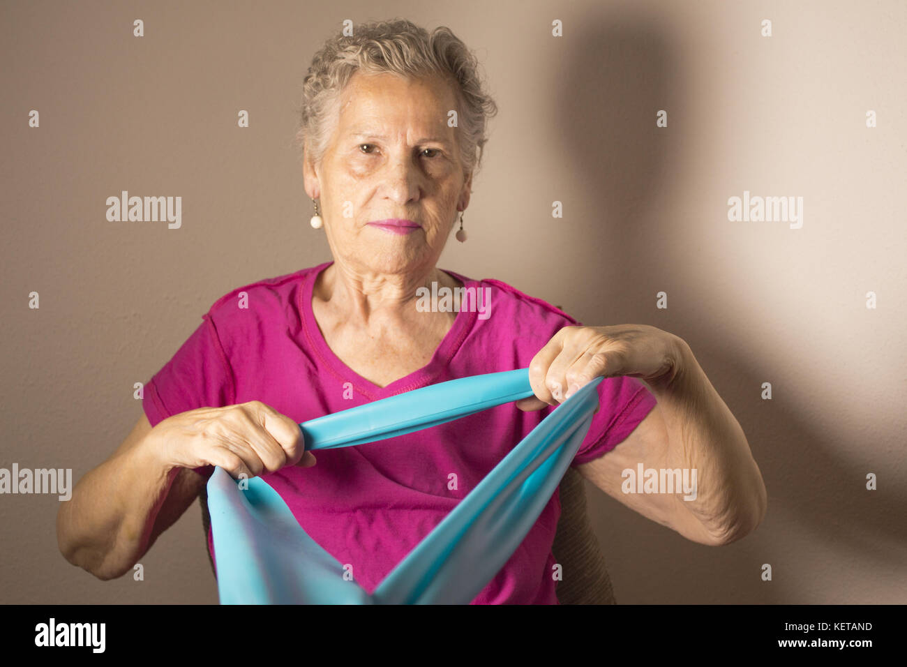 Rehabilitation exercises for older women with elastic band Stock Photo