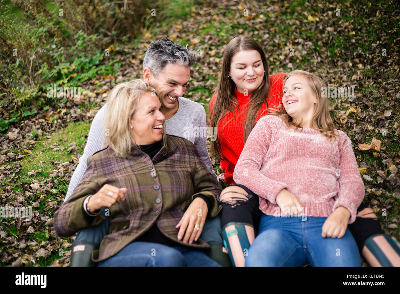 family of four with teenagers in park Stock Photo