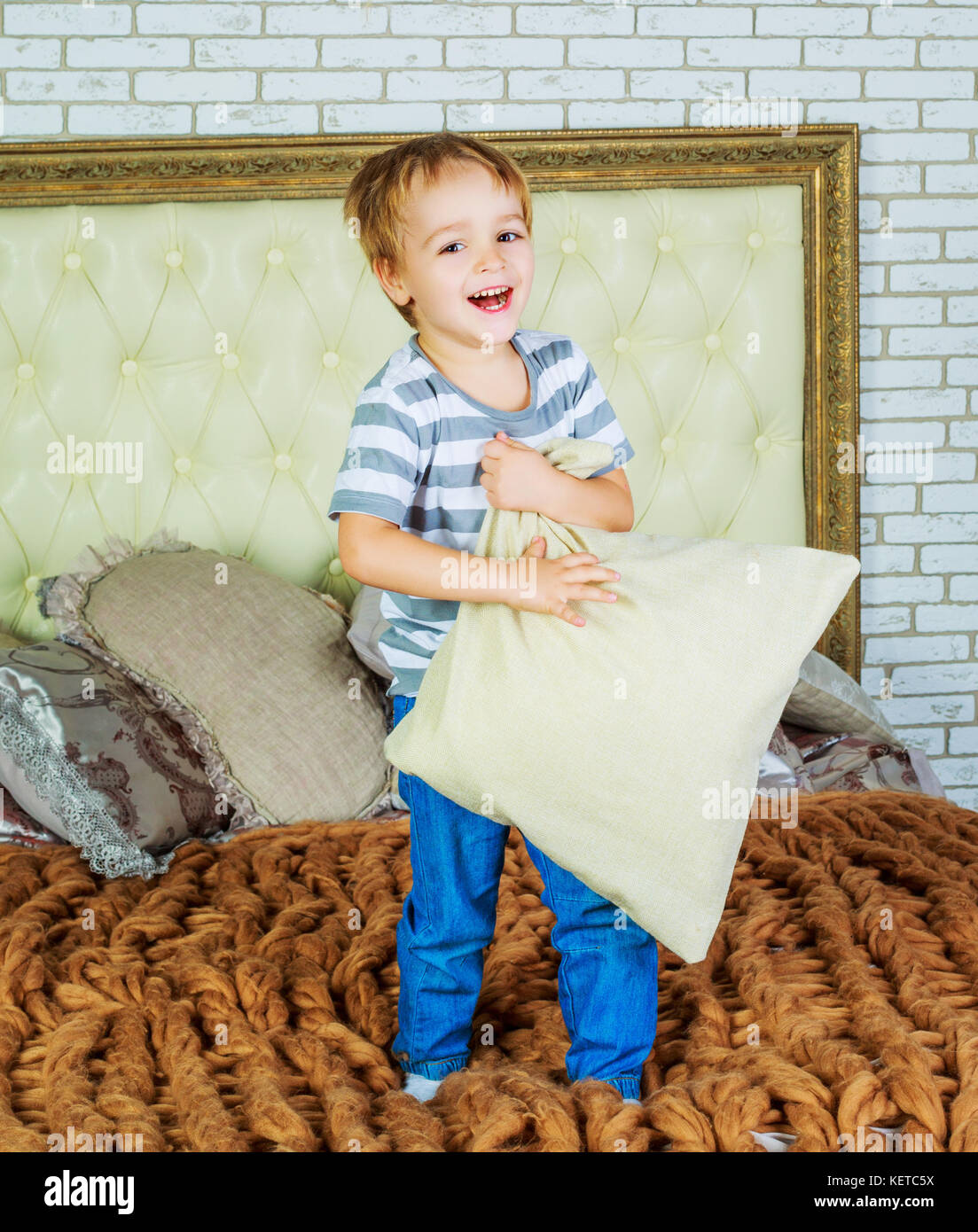 happy child with a pillow in bed at home Stock Photo Alamy