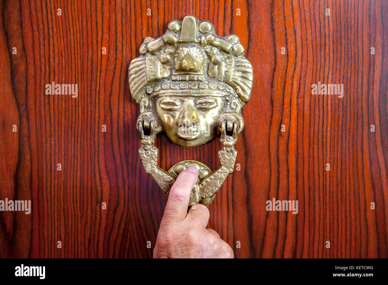 hand on Mexican brass door knocker Stock Photo Alamy