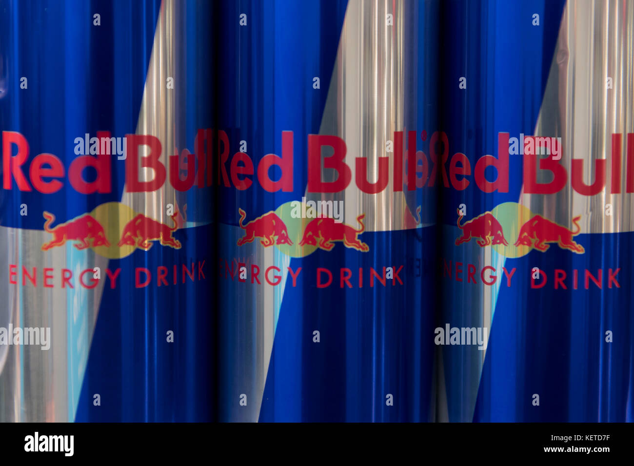 Cans of energy drink Red Bull on display on a supermarket store shelf. Stock Photo