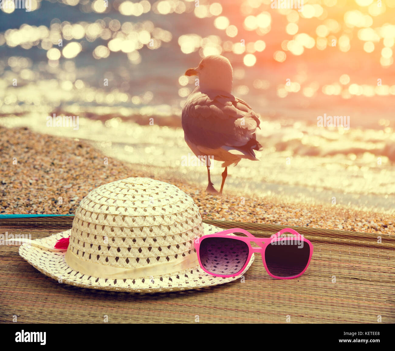 Beach scene. Sun straw hat and sunglasses lying on the sea on the beach ...