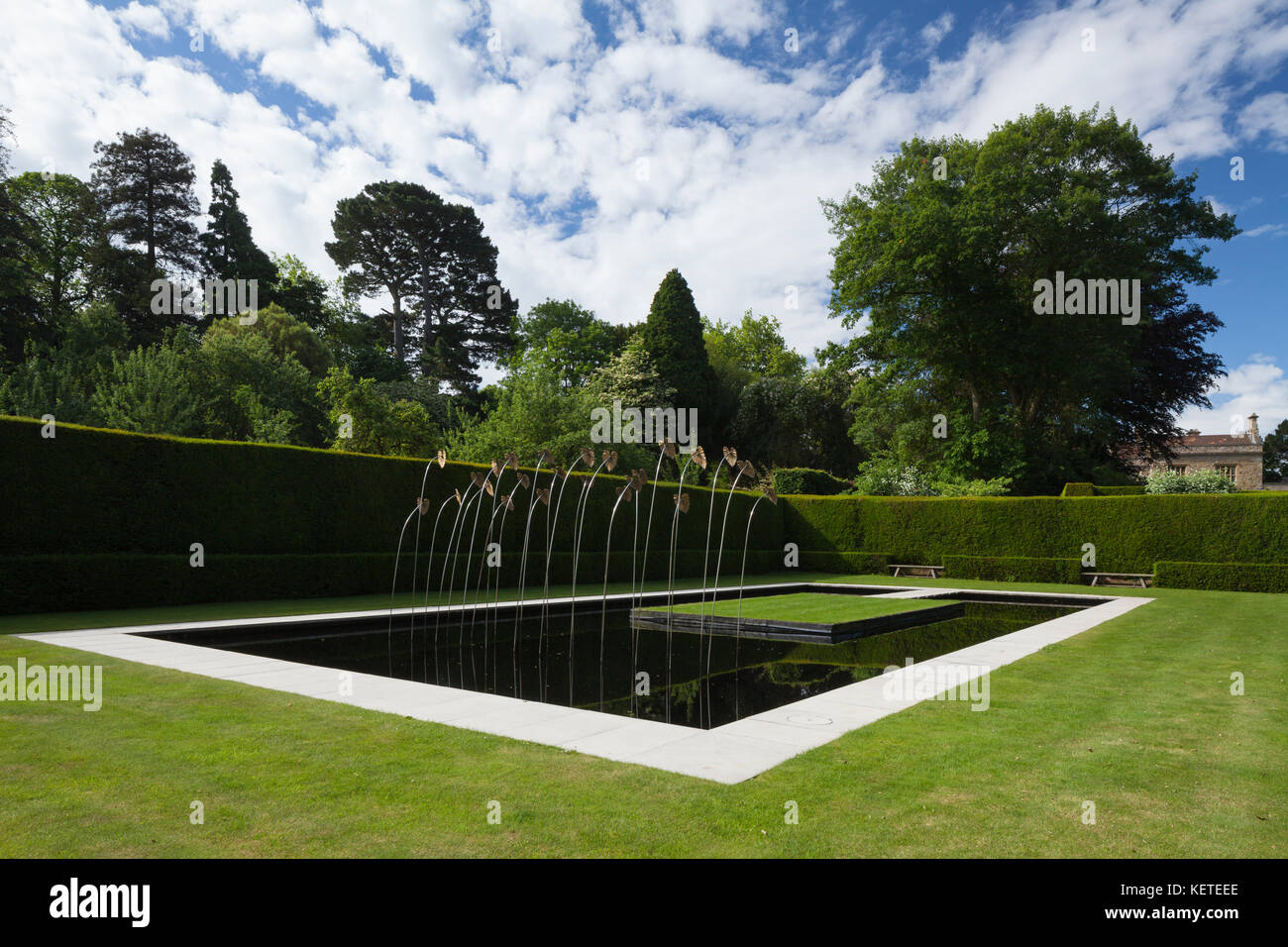 The contemporary Water Garden with modern art sculpture is enclosed by high yew hedges, Kiftsgate Court gardens, Cotswolds, Gloucestershire, England. Stock Photo