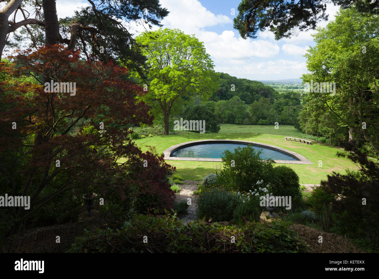 A view of the semi-circular pool in the lower garden seen from the Middle Banks garden of Kiftsgate Court, Cotswolds, Gloucestershire, England. Stock Photo