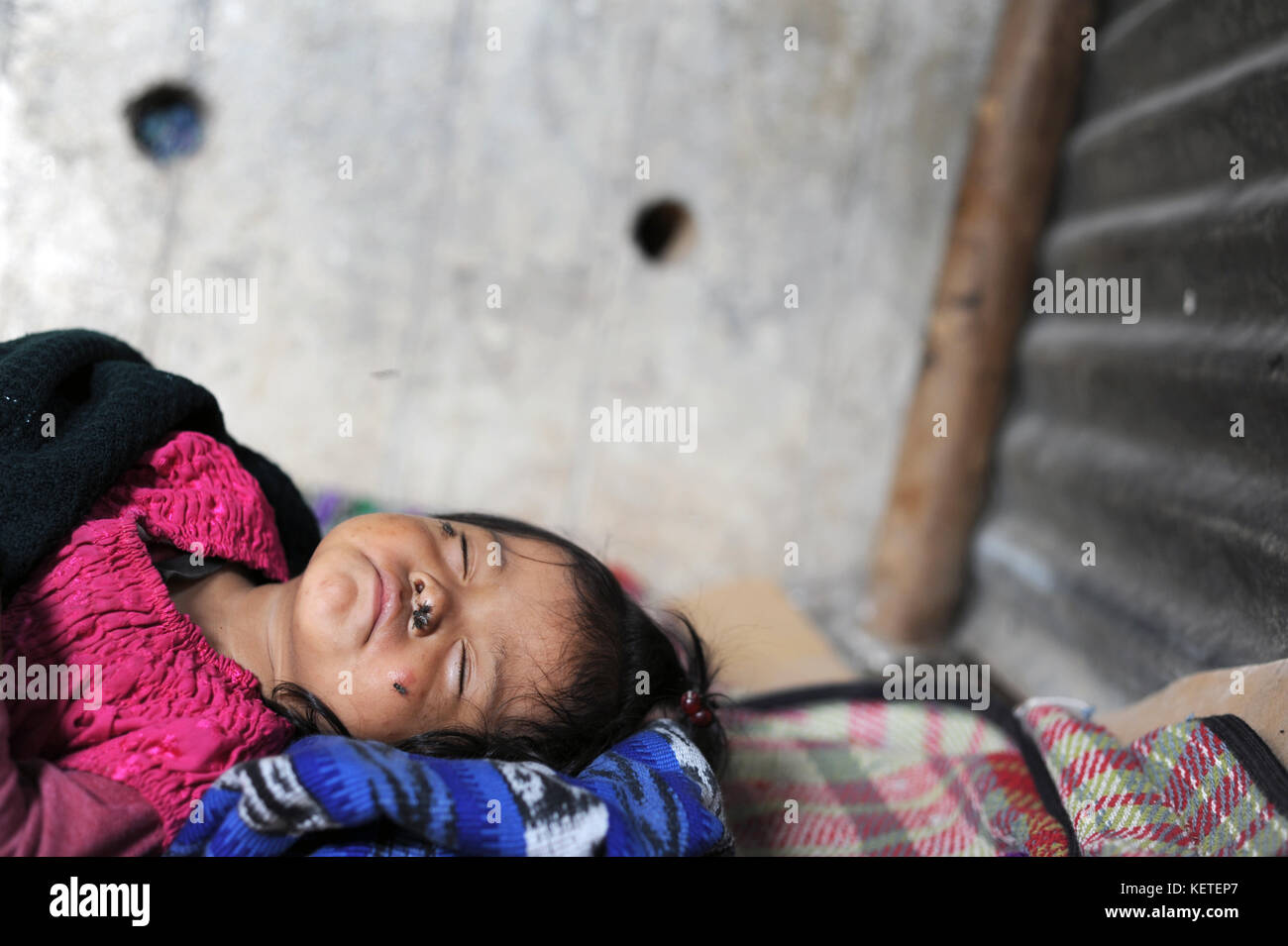 A sick maya indigenous girl rests on the floor in her home in San Antonio Palopo, Solola, Guatemala,. Stock Photo