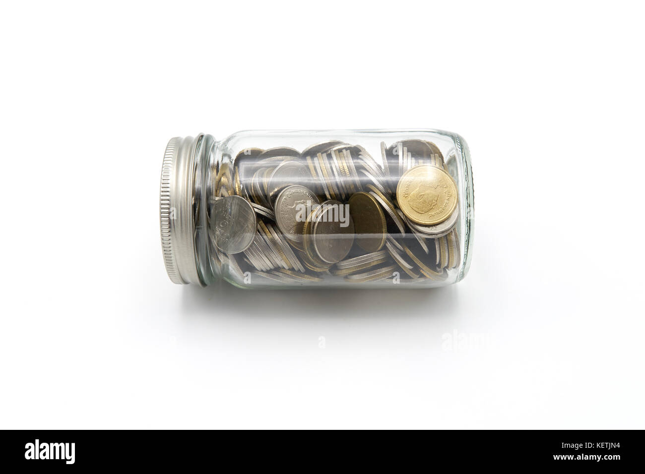 Saving money concept of collecting coins (Thai money) in a glass bottle
