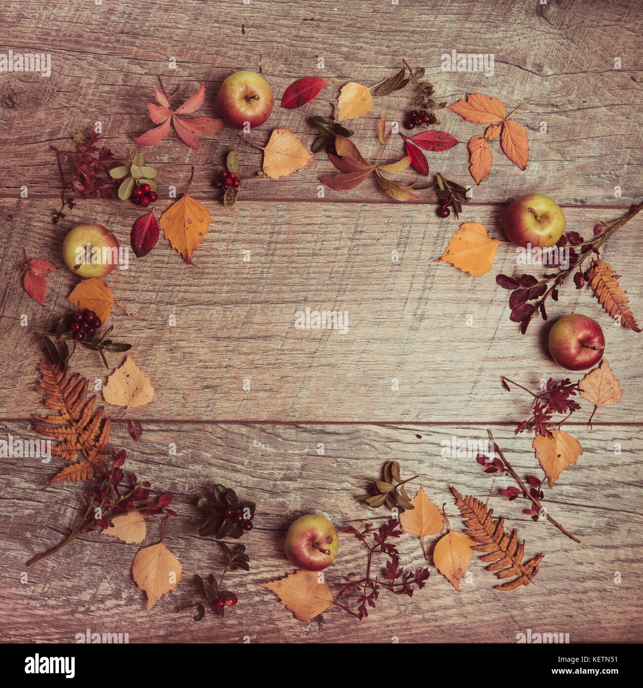 Autumn arrangement of leaves, apples and berries on a wooden background with free space for text. Top view, concept of the season Stock Photo