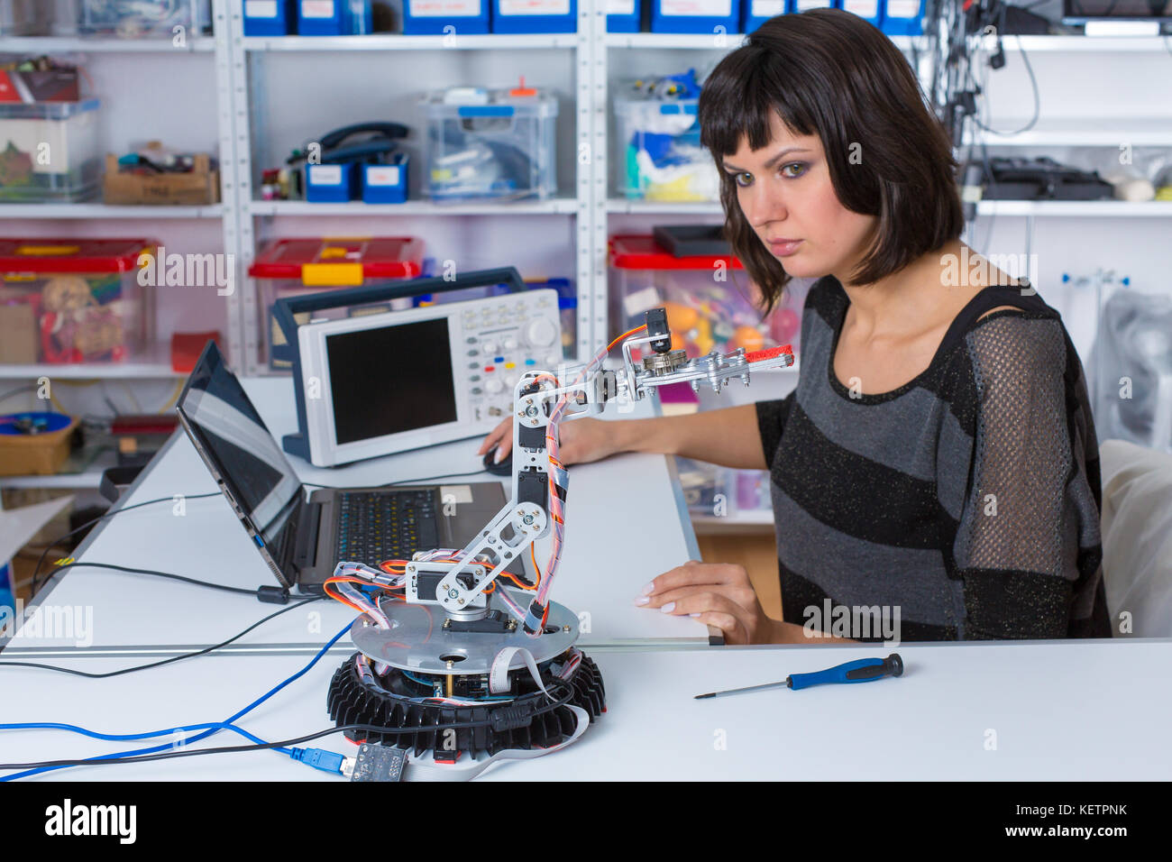 Female in robotics laboratory. Young woman experiment with robot Stock Photo