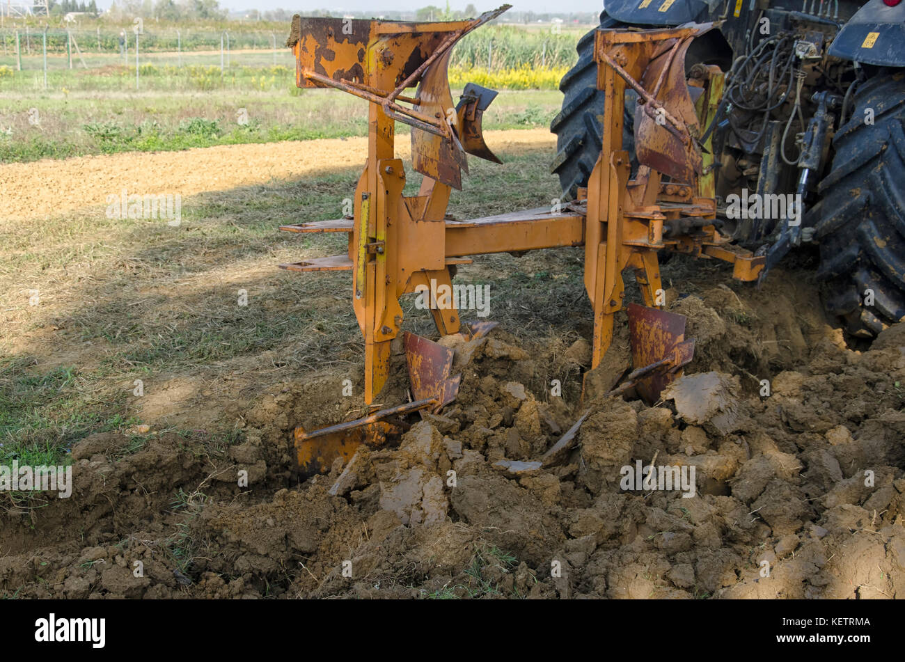View of farm tractor that plows the land Stock Photo - Alamy