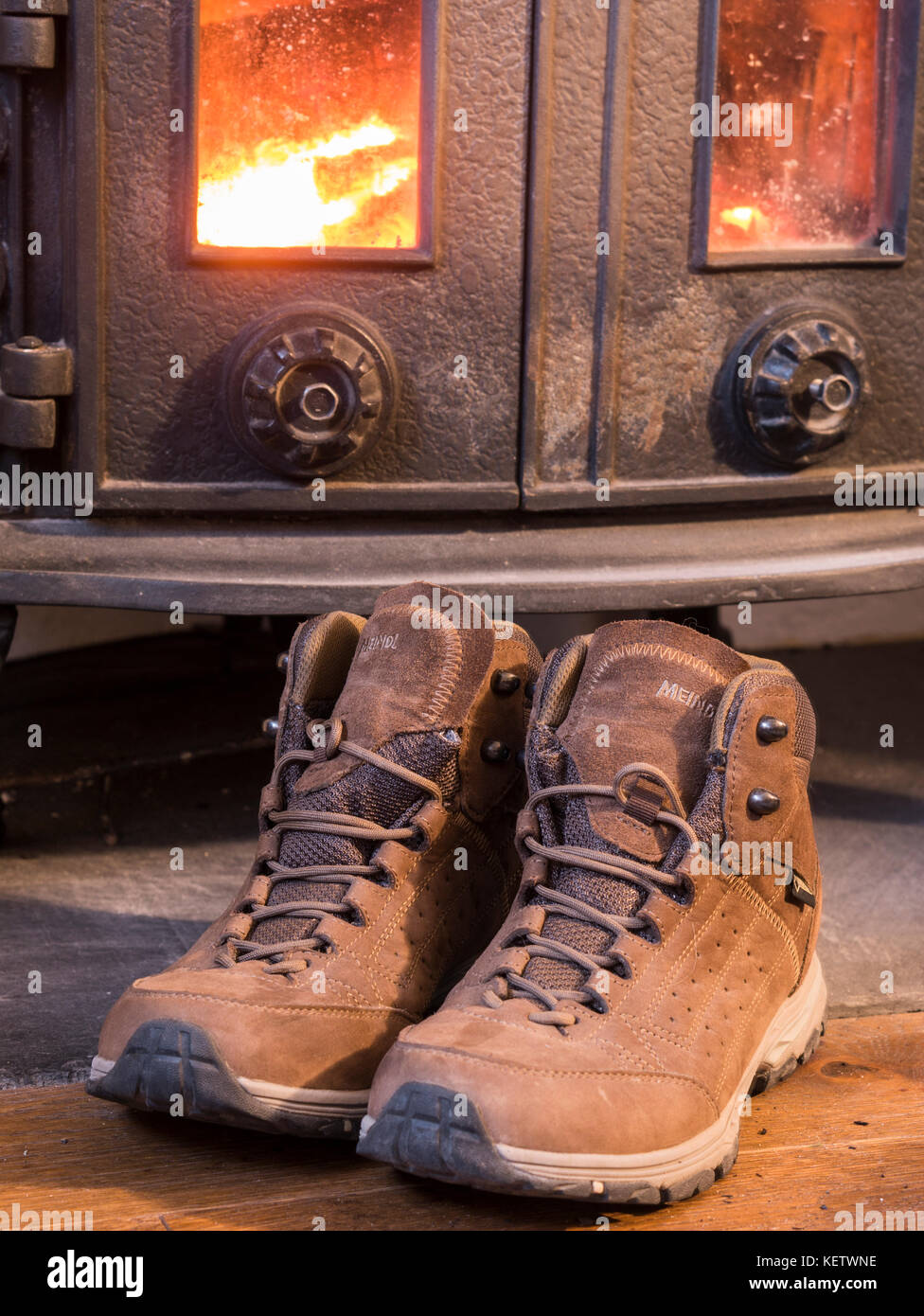 Walking boots drying by log burner Stock Photo Alamy