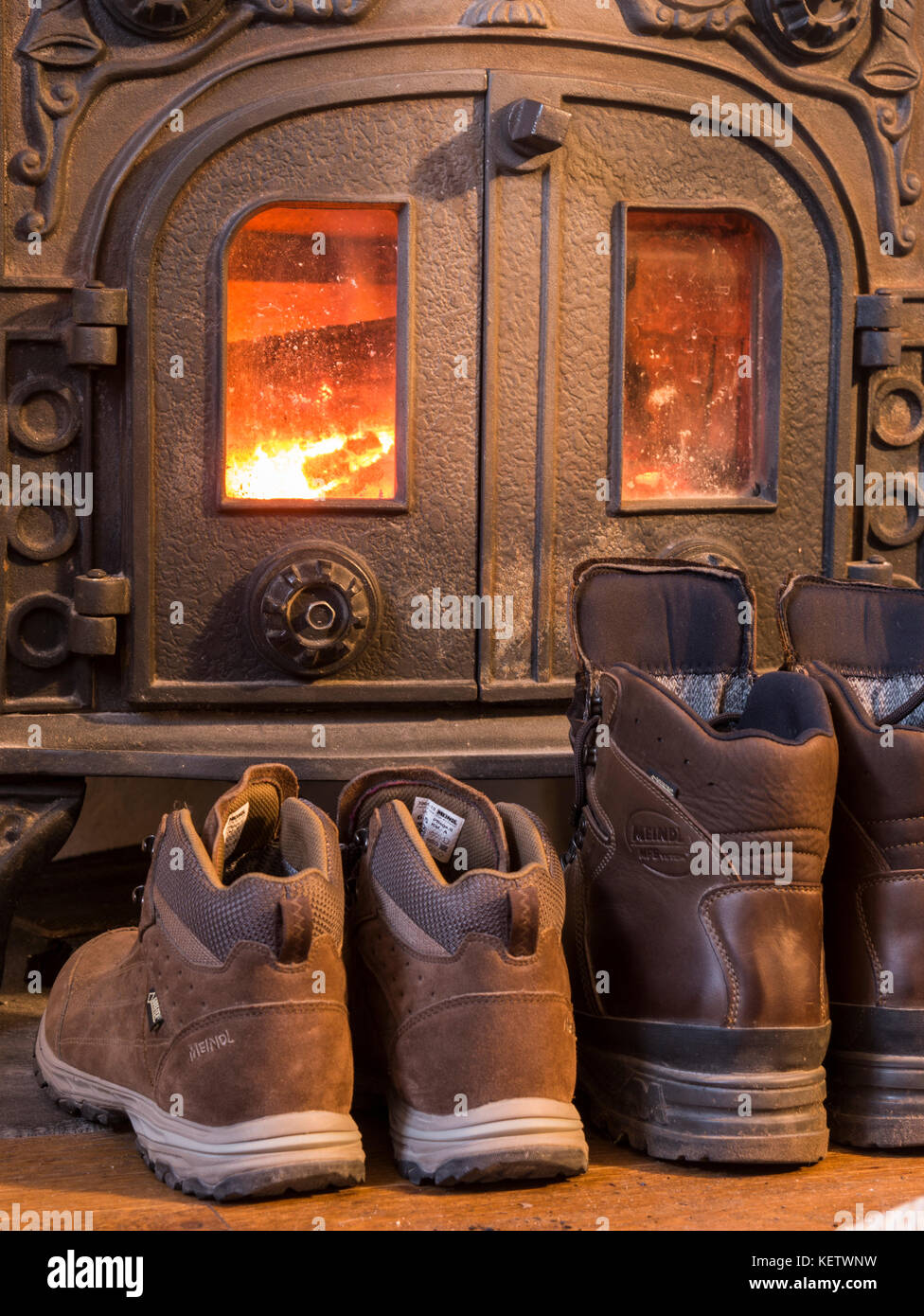 Walking boots drying by log burner Stock Photo Alamy