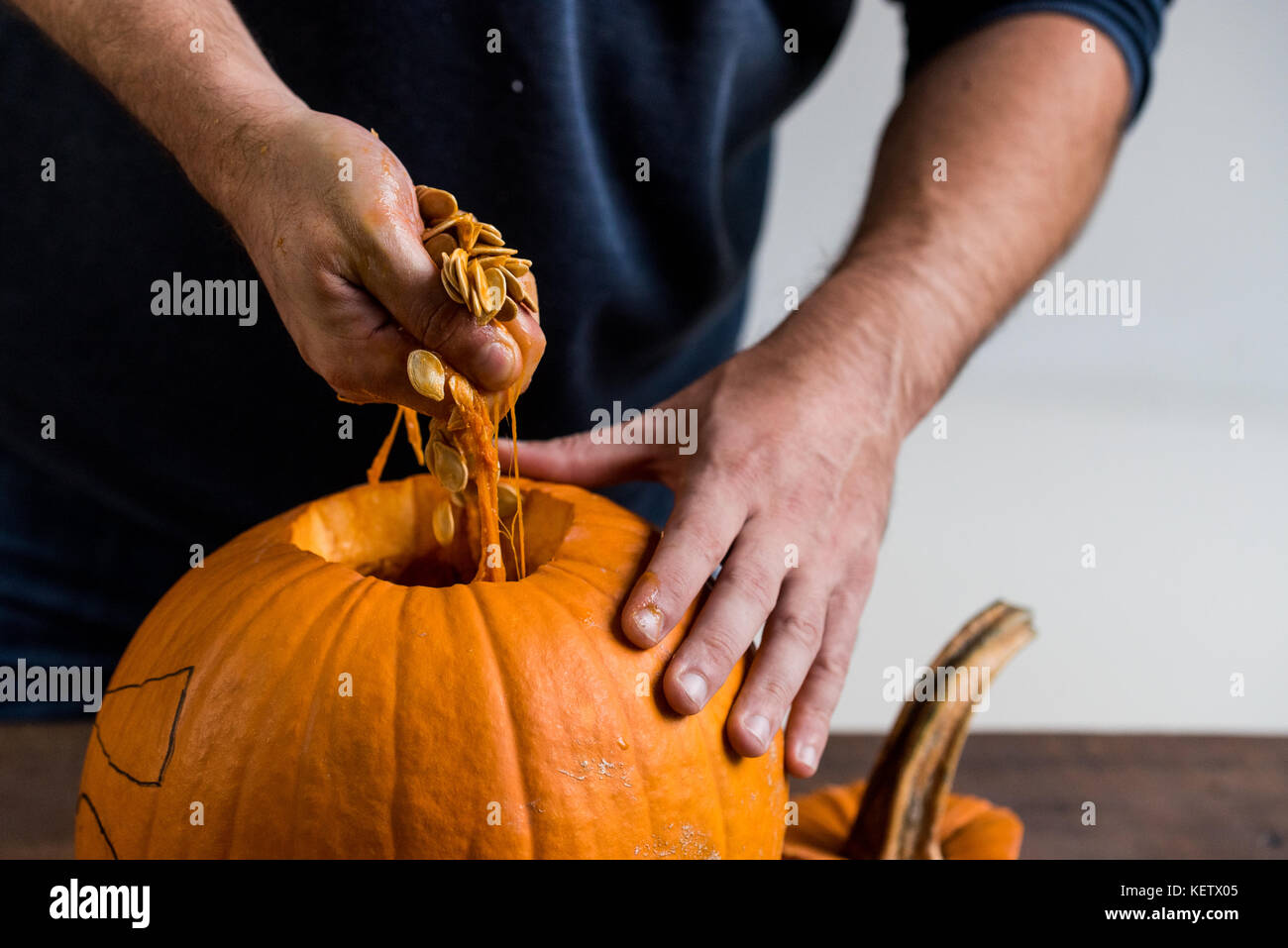 Male hands carving pumpkin taking out seeds Stock Photo - Alamy