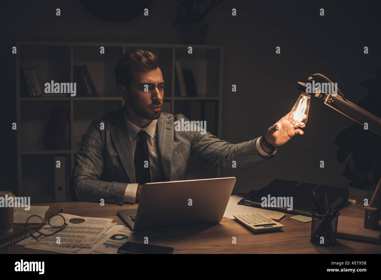 businessman touching table lamp at workplace Stock Photo