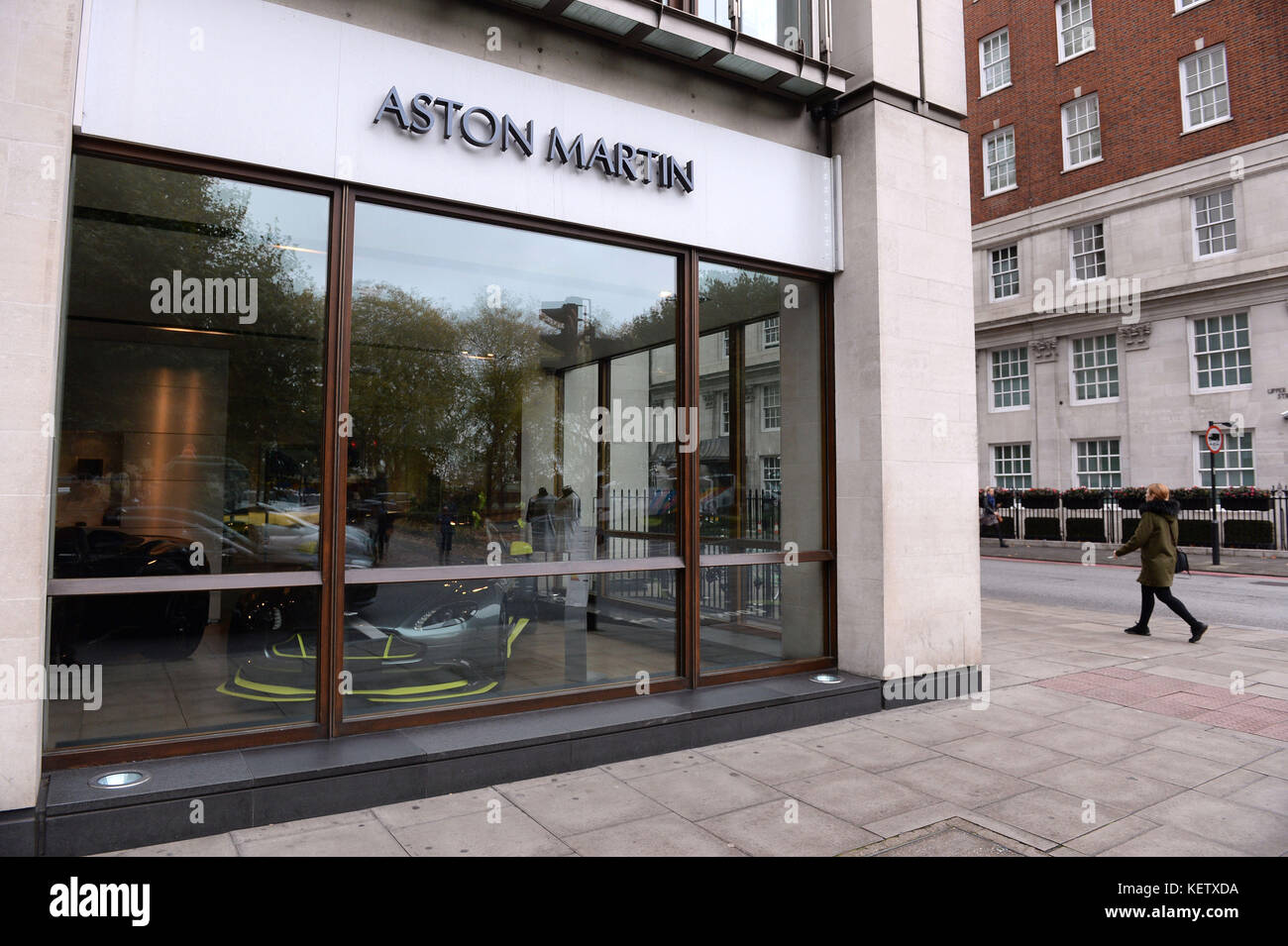 A person walks past the window of Stratstone's Aston Martin Mayfair dealership on Park Lane, London, whose parent company, Pendragon, has seen a tumble in its shares after warning that profits will take a hit from falling demand for new cars amid a decline in consumer confidence. Stock Photo