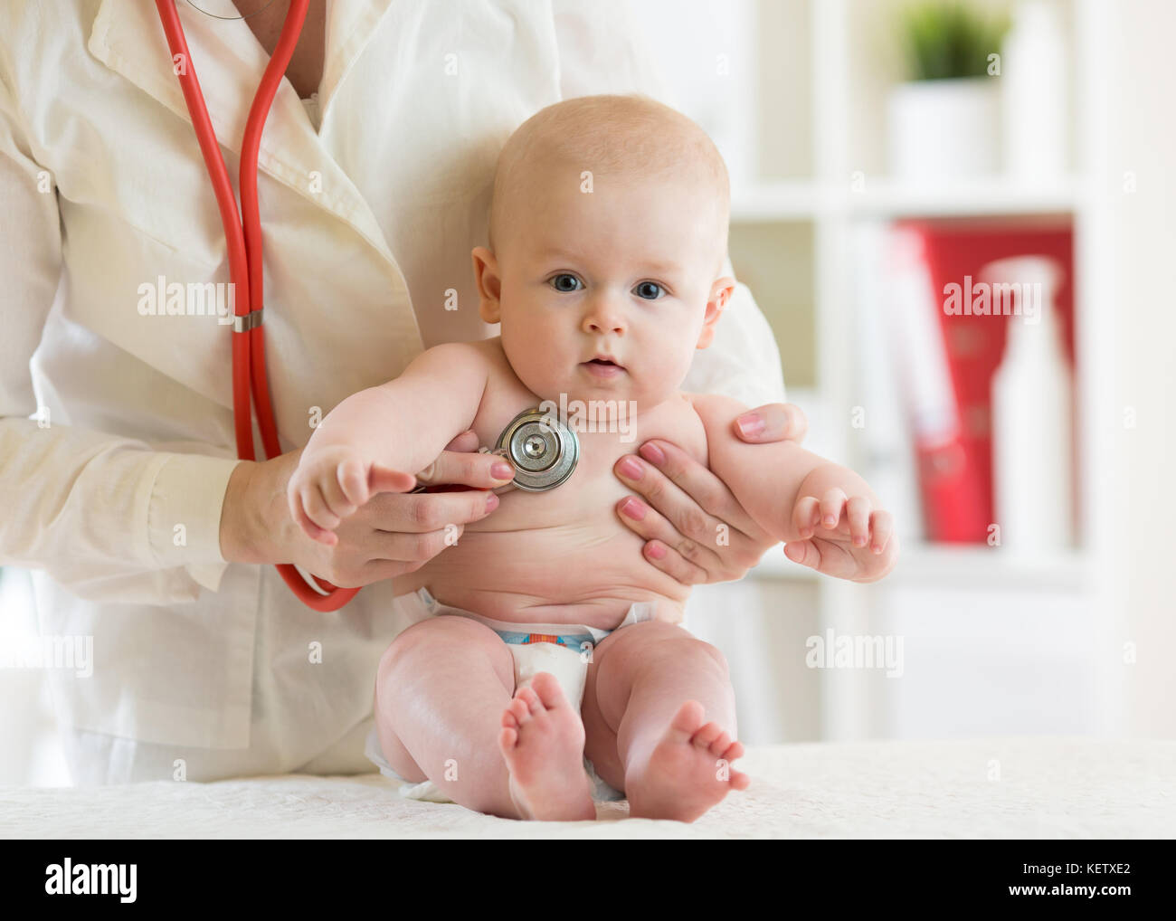 Doctor pediatric examining little child in clinic. Baby health concept Stock Photo