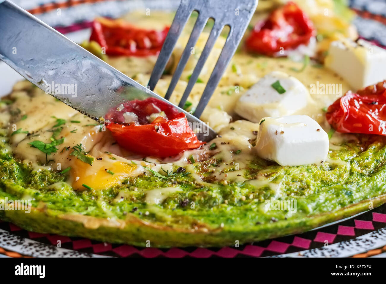 Spinach omelette with tomatoes and cheese on top Stock Photo