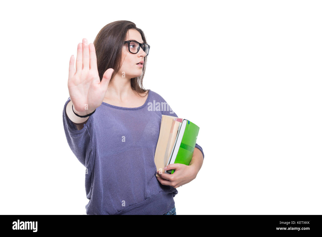 Schoolgirl with books doing stop gesture with her hand isolated on ...