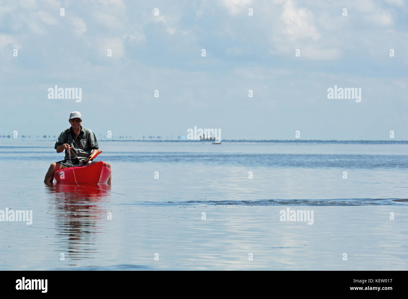 A fly fisherman fishing for tailing redfish or red drum from a kayak on the shallow flats near Port Aransas, Texas Stock Photo