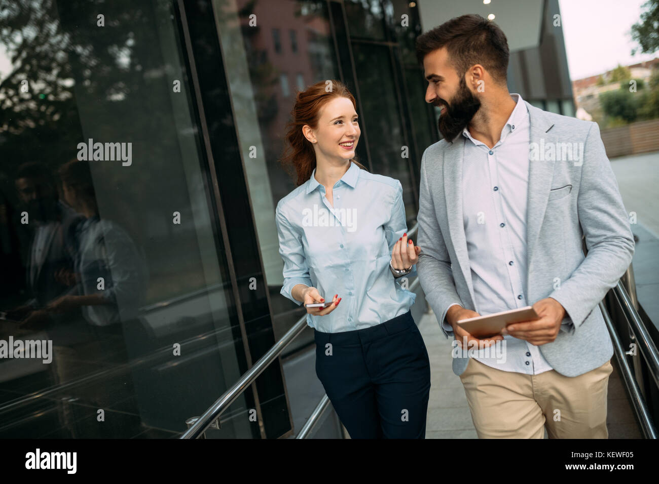Young business couple walking outdoor near office building Stock Photo ...