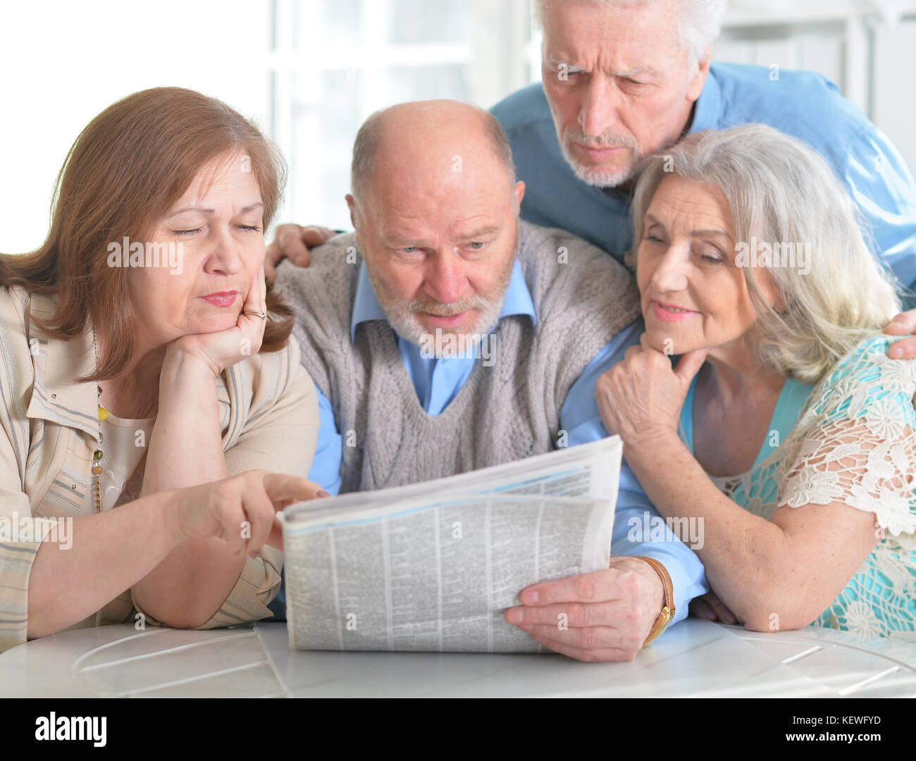 senior couples reading newspaper Stock Photo