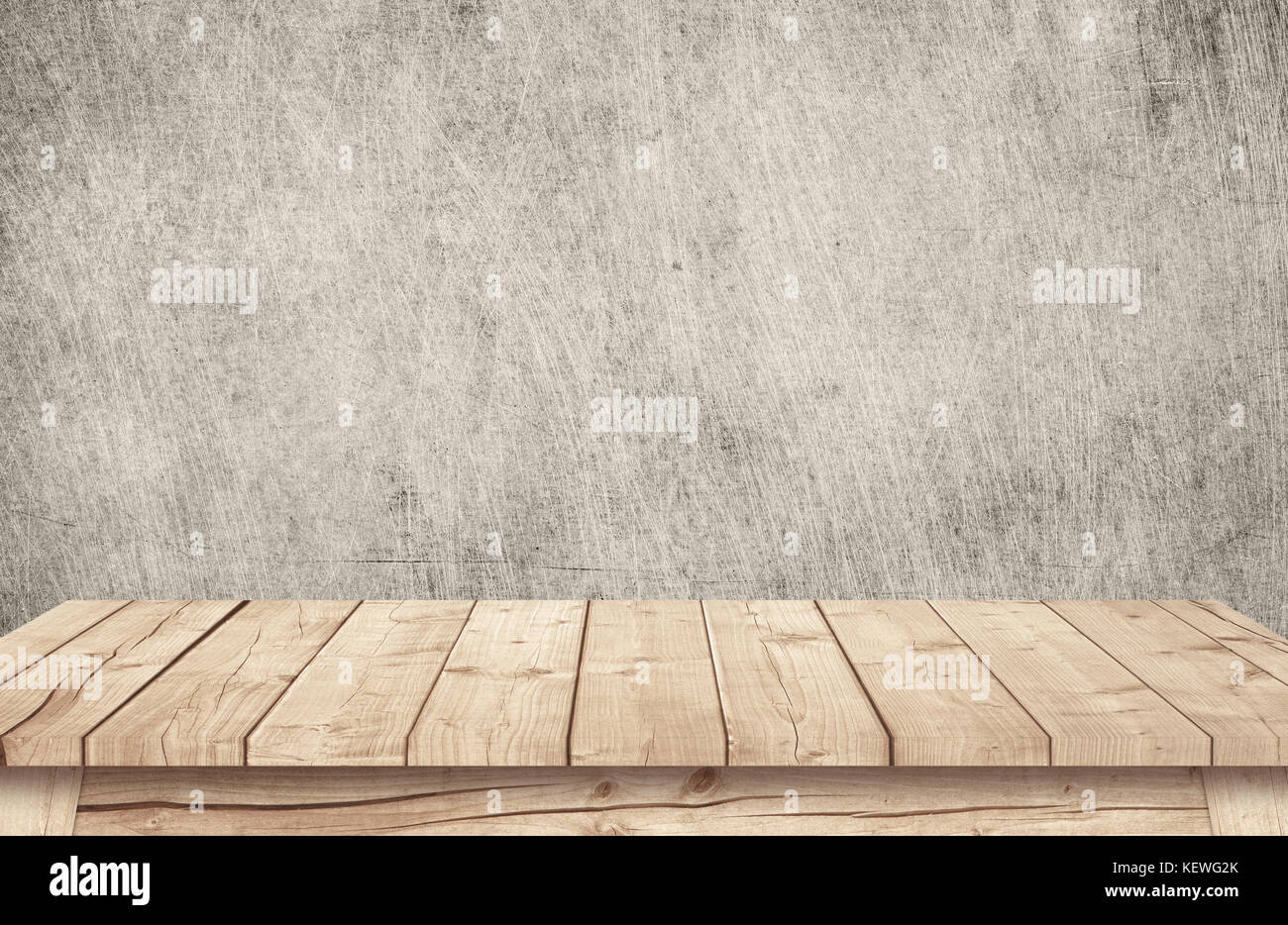 Brown wooden table top near scratched grunge wallpaper. Stock Photo