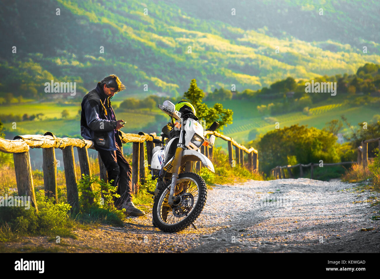 on a off road motocross track a biker rest at the sunset on a wooden fence in the Colli Euganei, Italy, 22 Apr 2017 Stock Photo