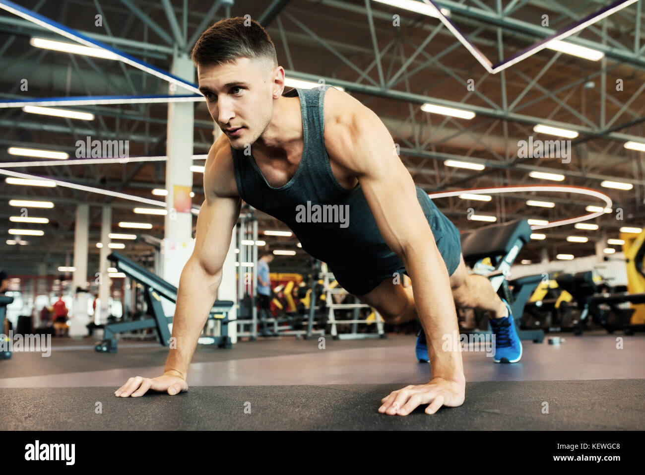Strong Man Doing Push Ups in Gym Stock Photo