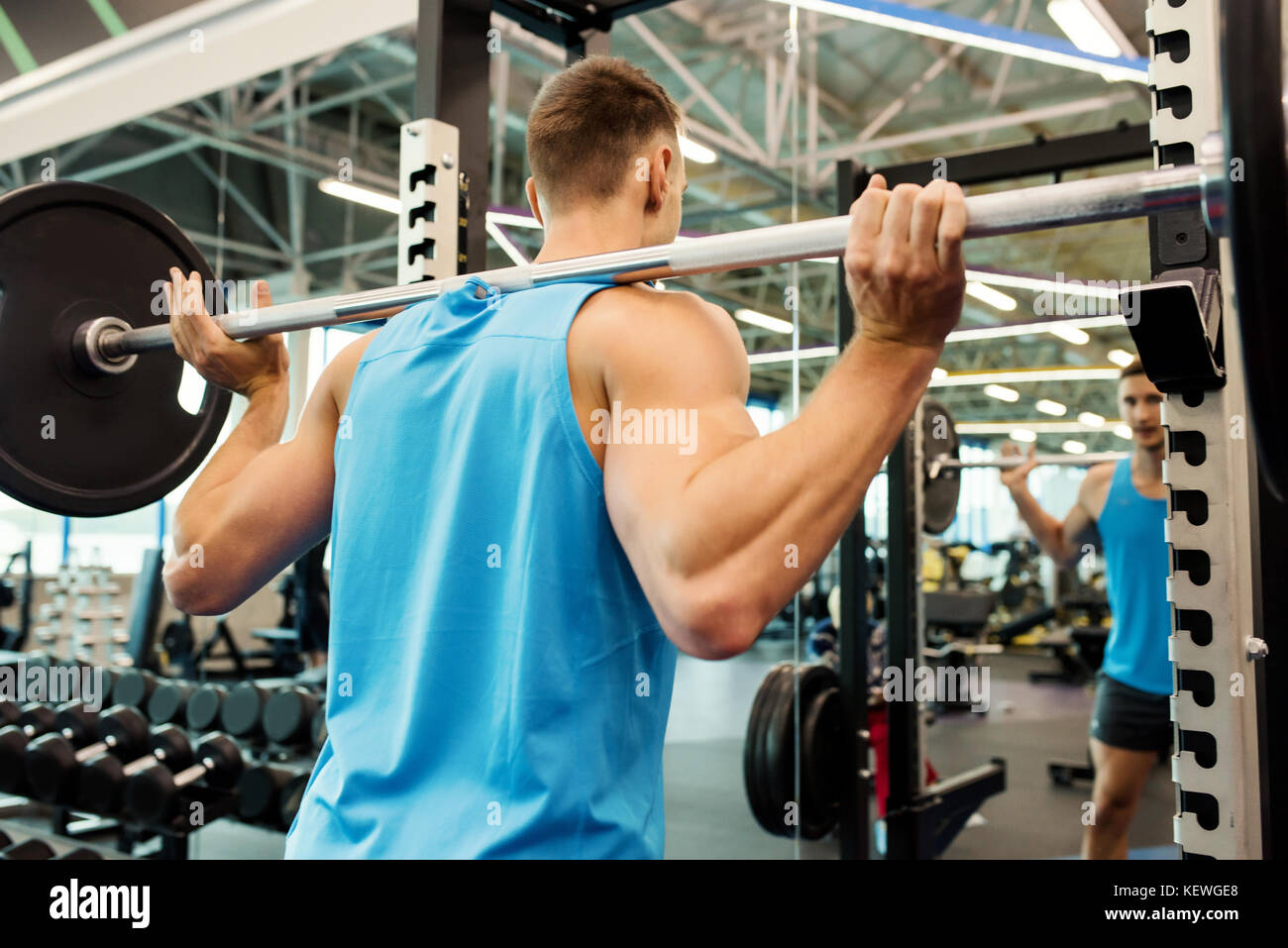 Strong Man Lifting Barbell in Gym Stock Photo