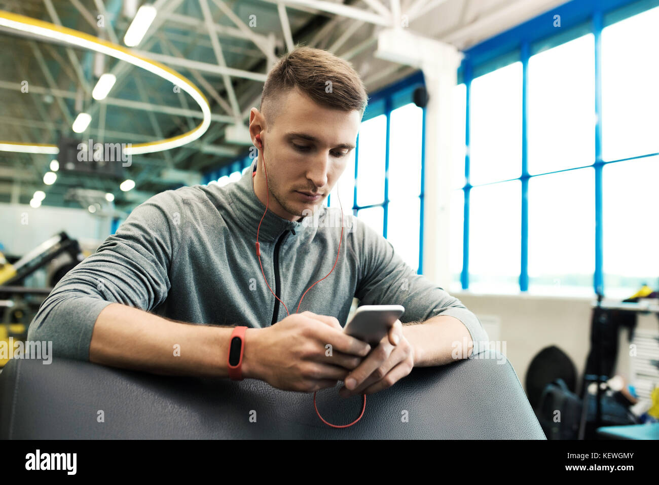 Modern Sportsman using Smartphone in Gym Stock Photo