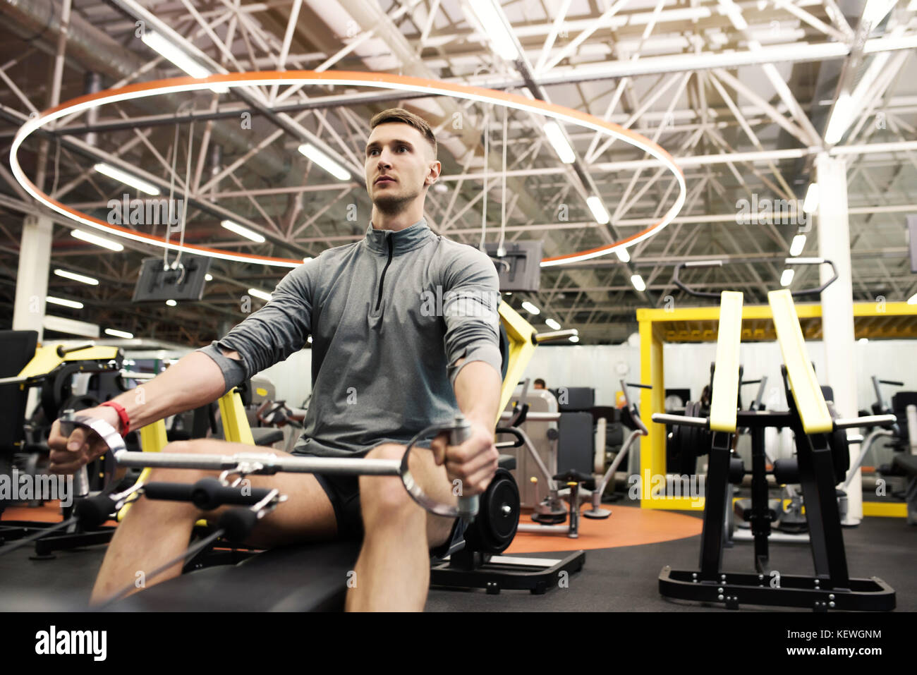 Sportsman Using Machines in Gym Stock Photo