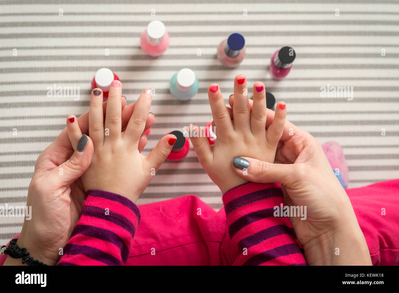 Mother and daughter having fun painting fingernails, family time