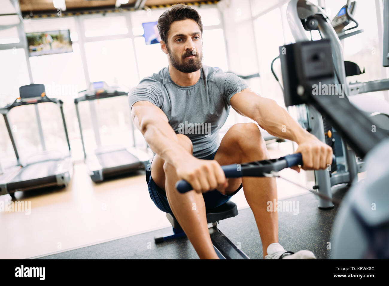 Young handsome man doing exercises in gym Stock Photo