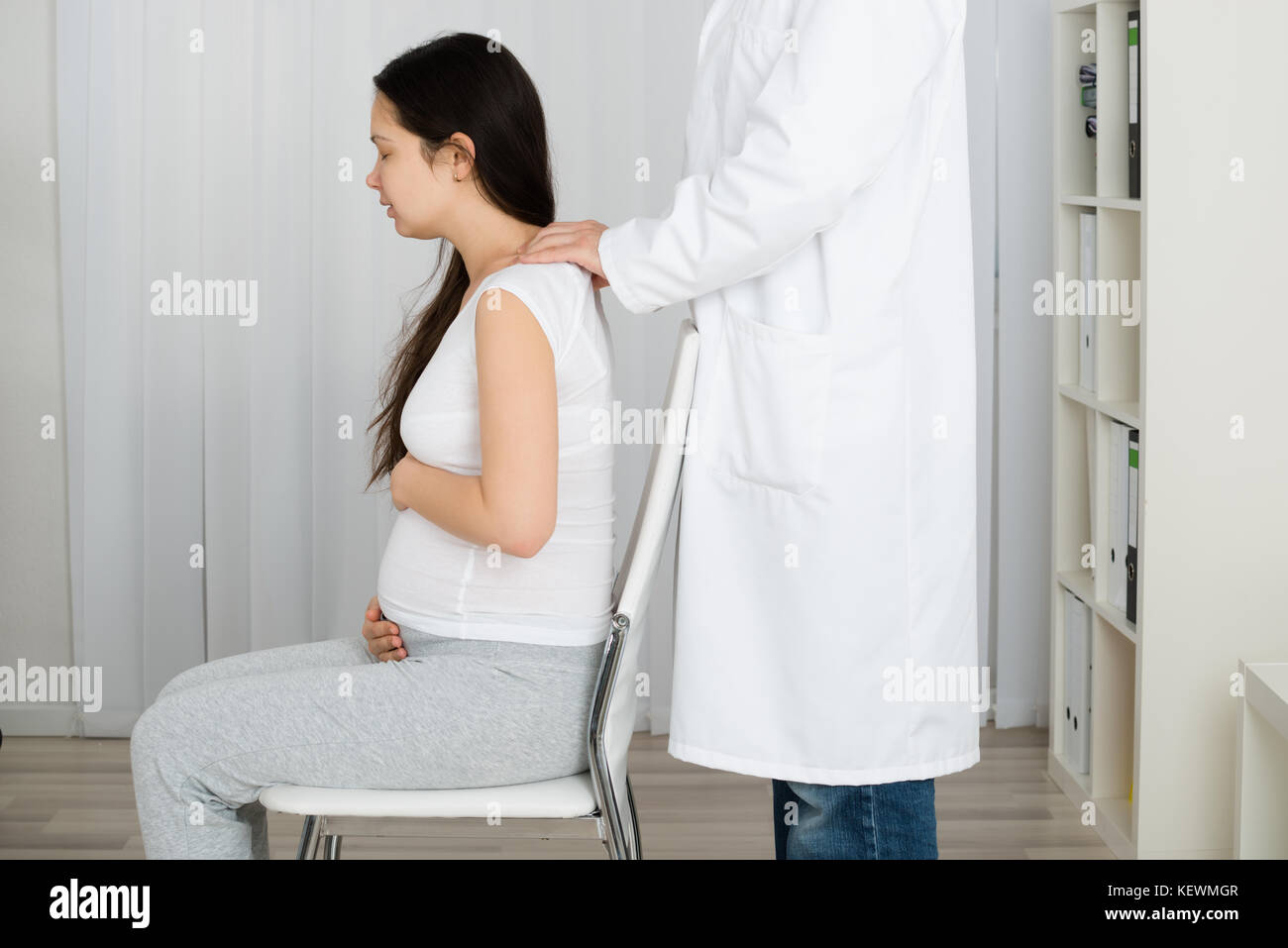 Man Massaging Pregnant Woman Sitting On Chair Stock Photo Alamy