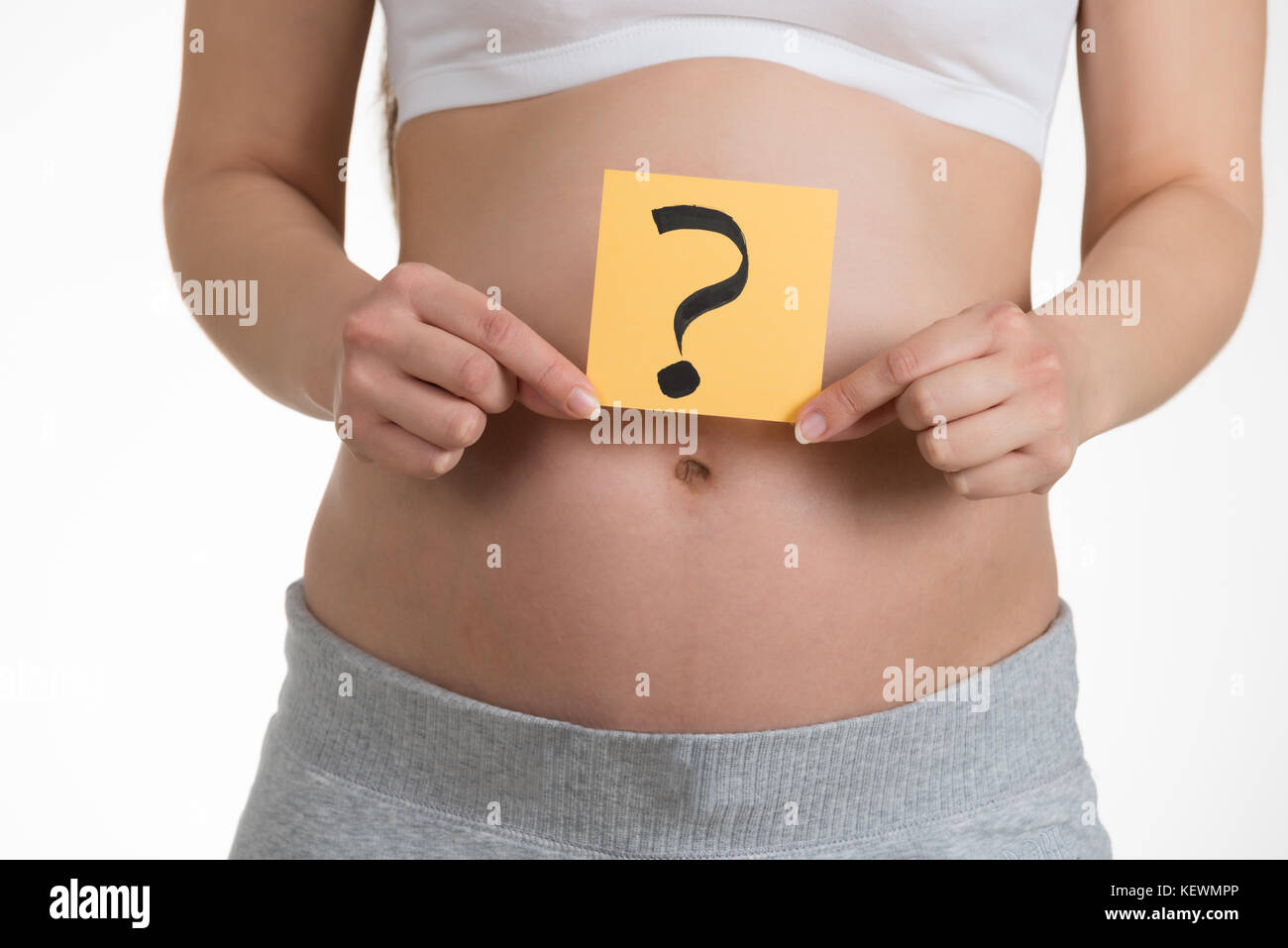 Midsection Of Pregnant Woman Holding Paper With Question Mark Stock Photo