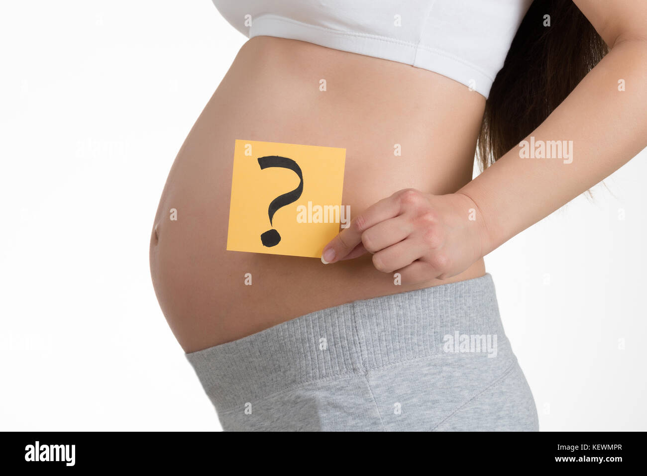 Midsection Of Pregnant Woman Holding Paper With Question Mark Stock Photo