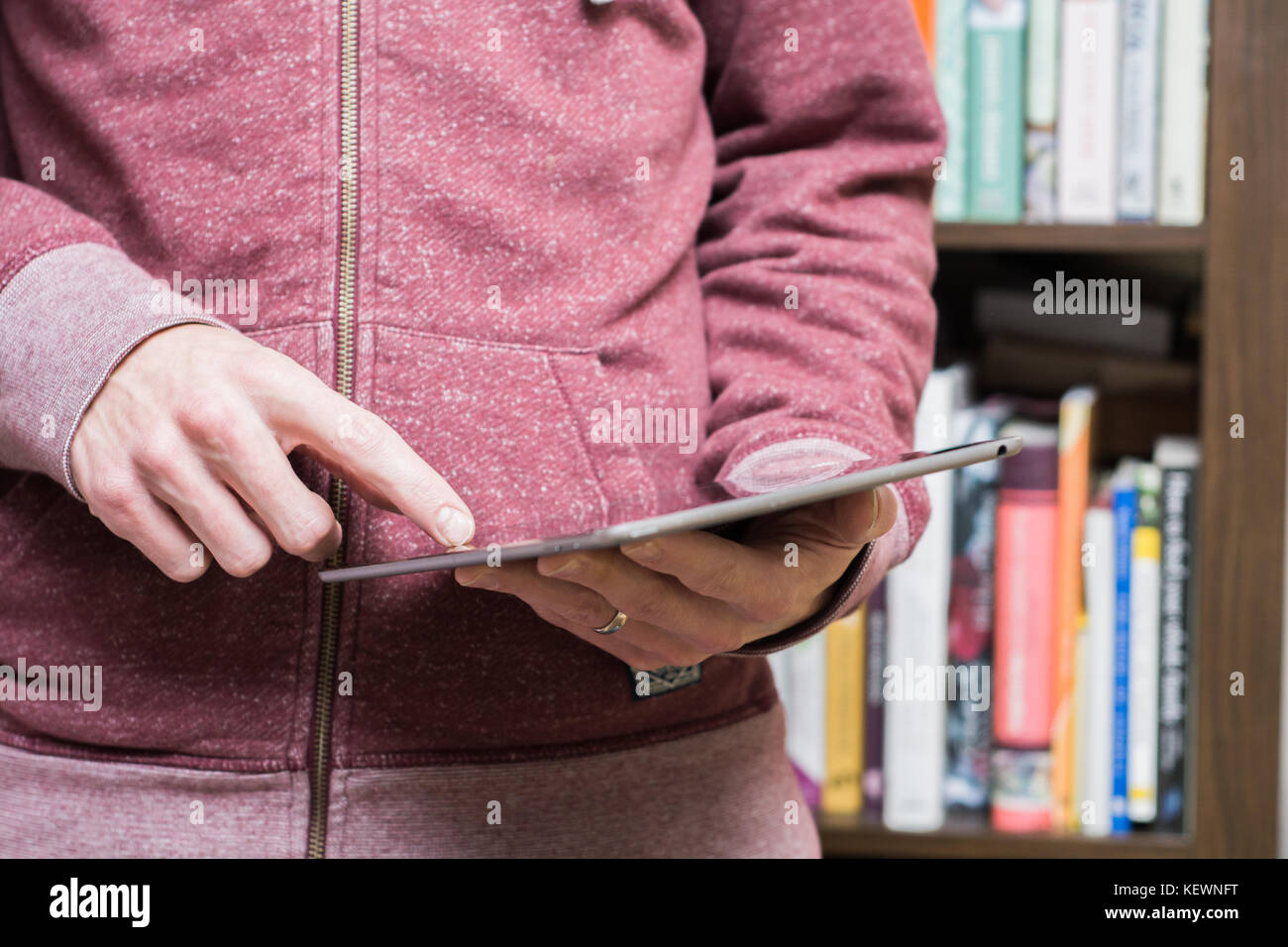 Student Using Touch Screen Student man in a hoodie using a touch screen tablet Stock Photo - Alamy
