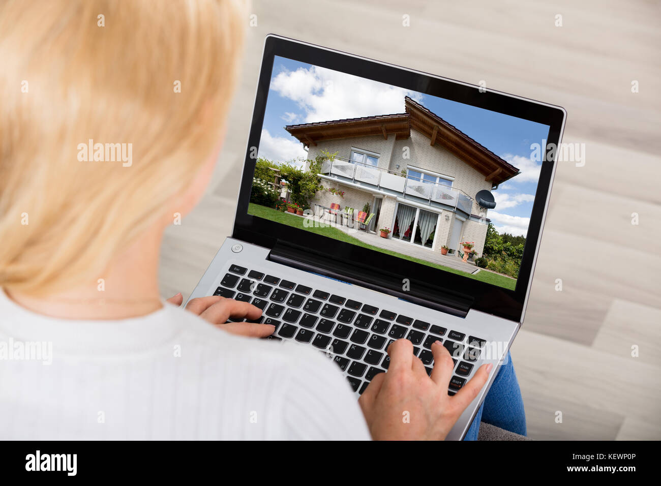 High Angle View Of A Woman Looking At House On Laptop Computer Screen Stock Photo