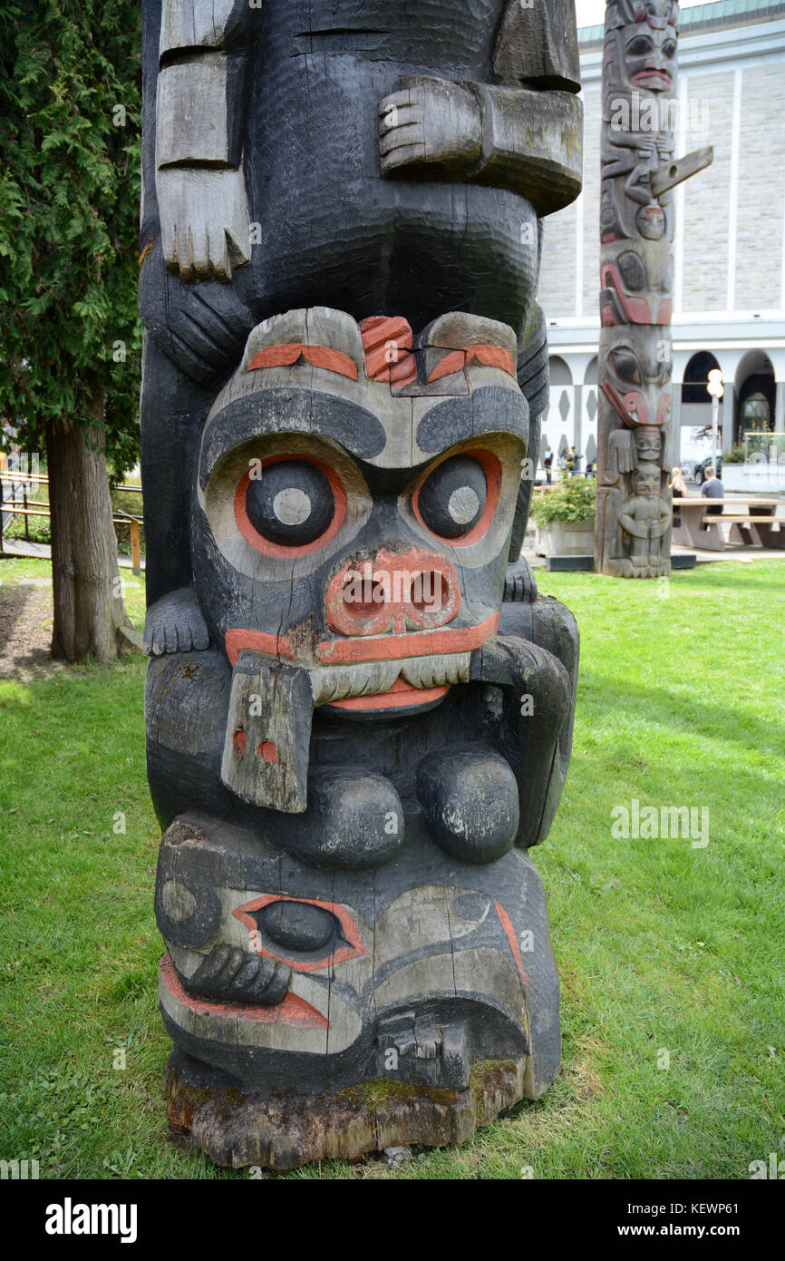 Traditional Northwest indigenous totem pole on display on the grounds of the Royal BC Museum, Victoria, British Columbia, Canada. Stock Photo