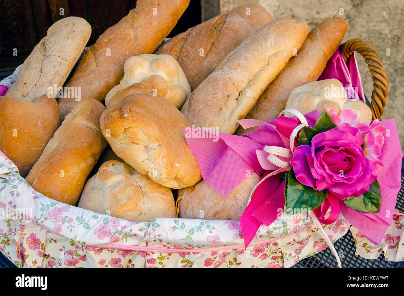 Traditional Italian bread loaves in basket with pink rose decoration Italy Stock Photo