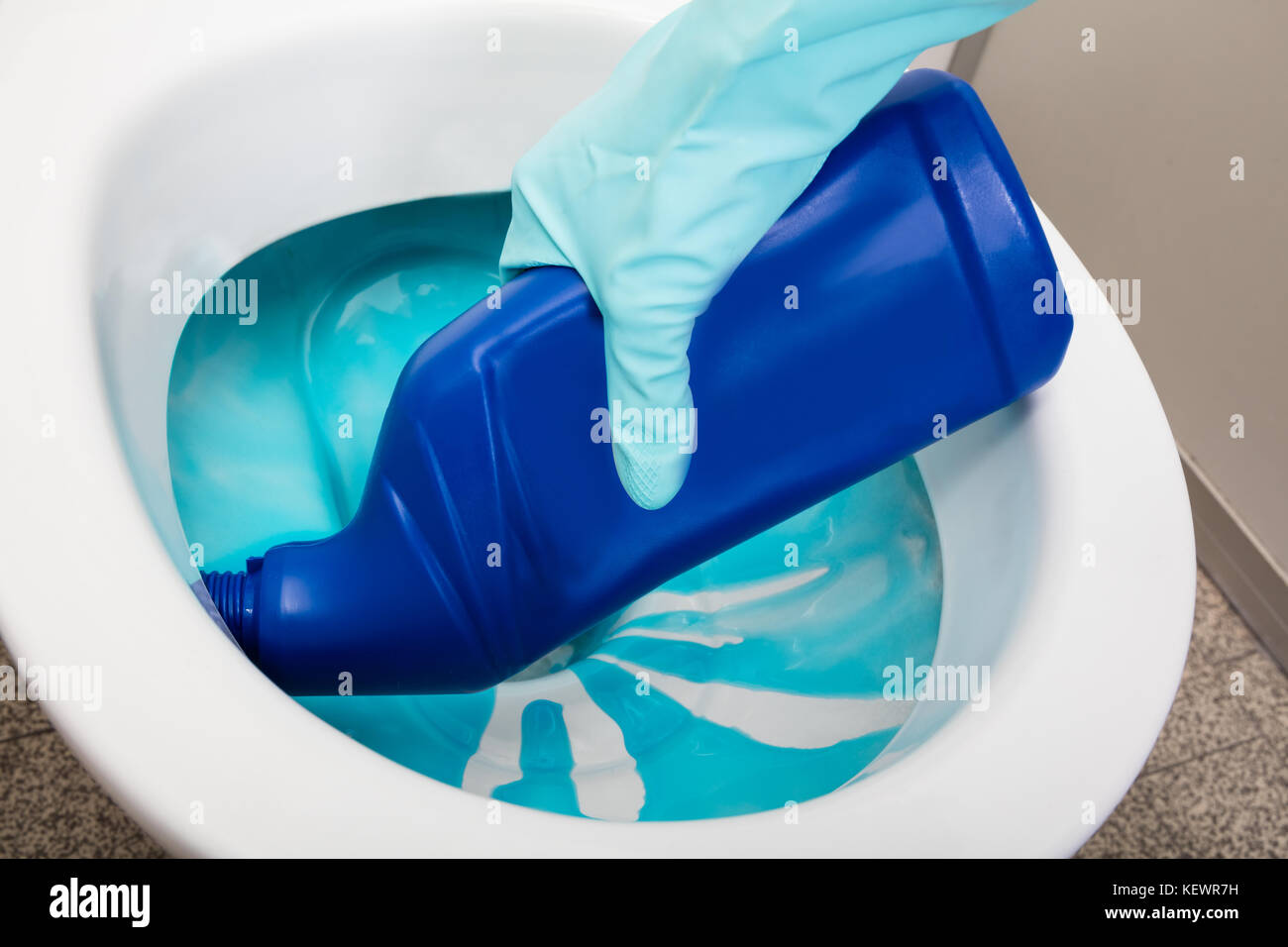 Closeup Of A Person's Hand Wearing Gloves Cleaning Toilet Using