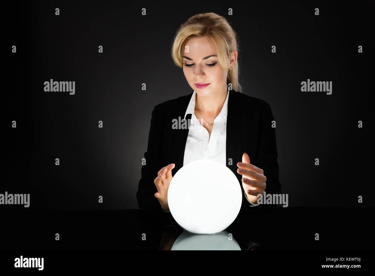 Businesswoman Looking Into The Future In A Crystal Ball On Black ...