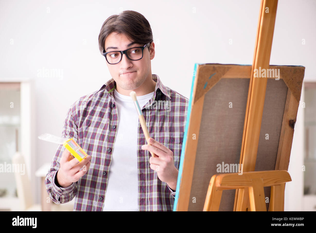 Young male artist drawing pictures in bright studio Stock Photo - Alamy