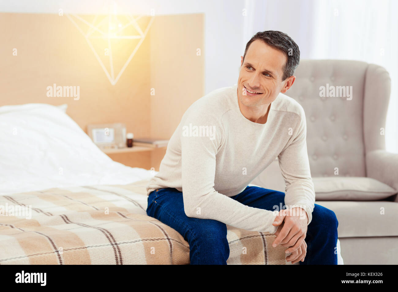 Dreamy male person sitting in his room Stock Photo