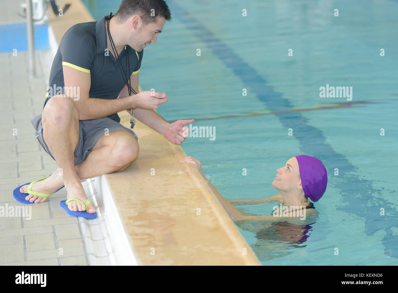 swimming coach holding stopwatch poolside at the leisure center Stock