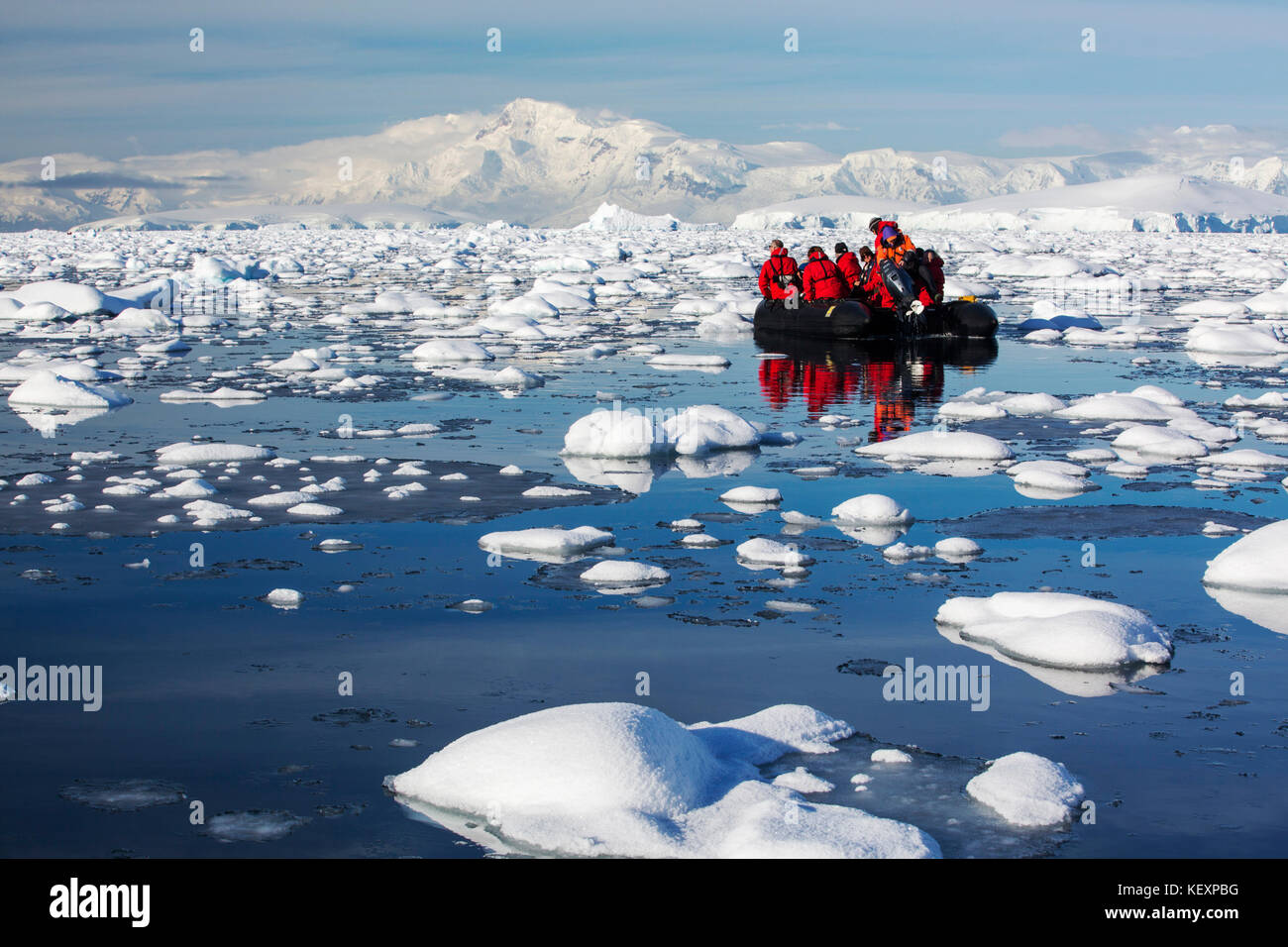 Members of an expedition cruise to Antarctica in a Zodiak in Fournier Bay in the Gerlache Strait on the Antarctic peninsula. The Antarctic peninsula is one of the most rapidly warming areas on the planet. Stock Photo