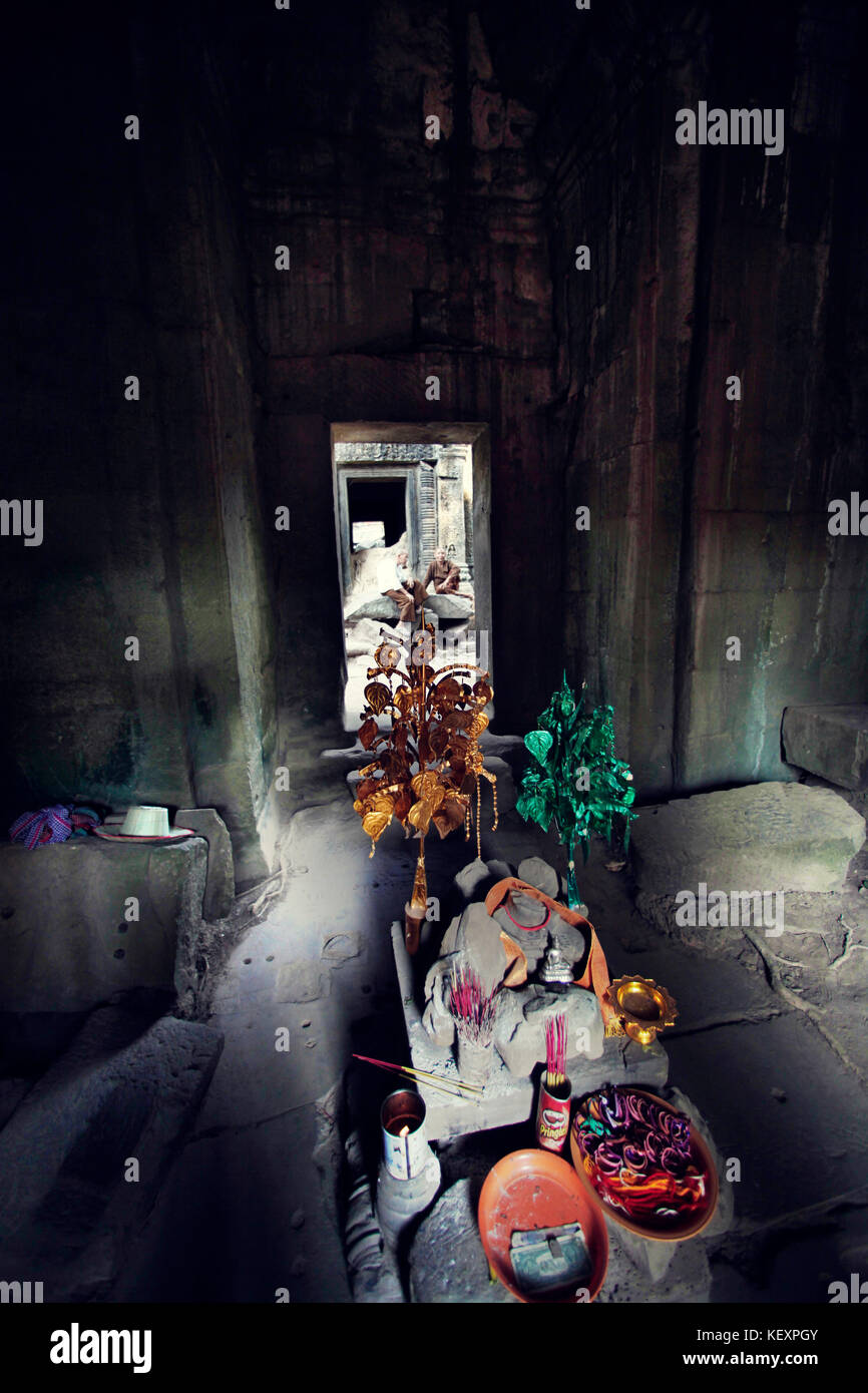 Photograph of monk in old temple waiting for offering, Angkor Wat, Siem Reap Province, Cambodia Stock Photo