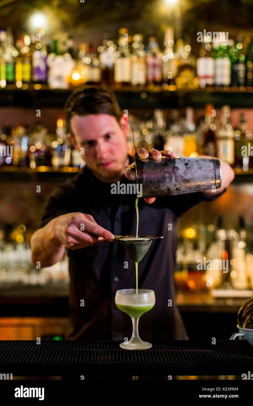 A bartender makes a fancy cocktail at a swanky bar in Seattle's Capital Hill neighborhood. Stock Photo