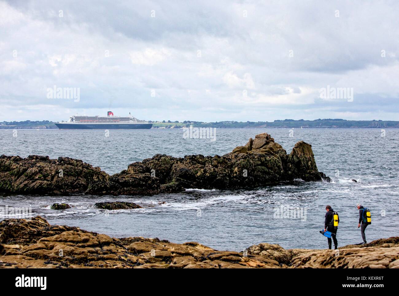 the Queen Mary 2 passing Groix Island, on her way to Saint Nazaire for the start of the centennial Transat The Bridge 2017, a historic transatlantic race between her and a fleet of giant trimarans. Stock Photo