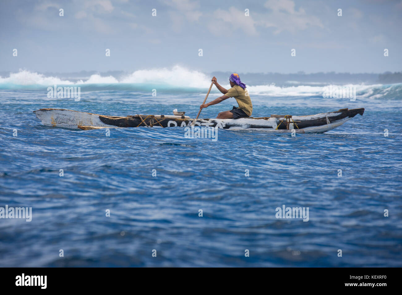 Photograph of local Samoan fisherman paddling in outrigger canoe, Samoa