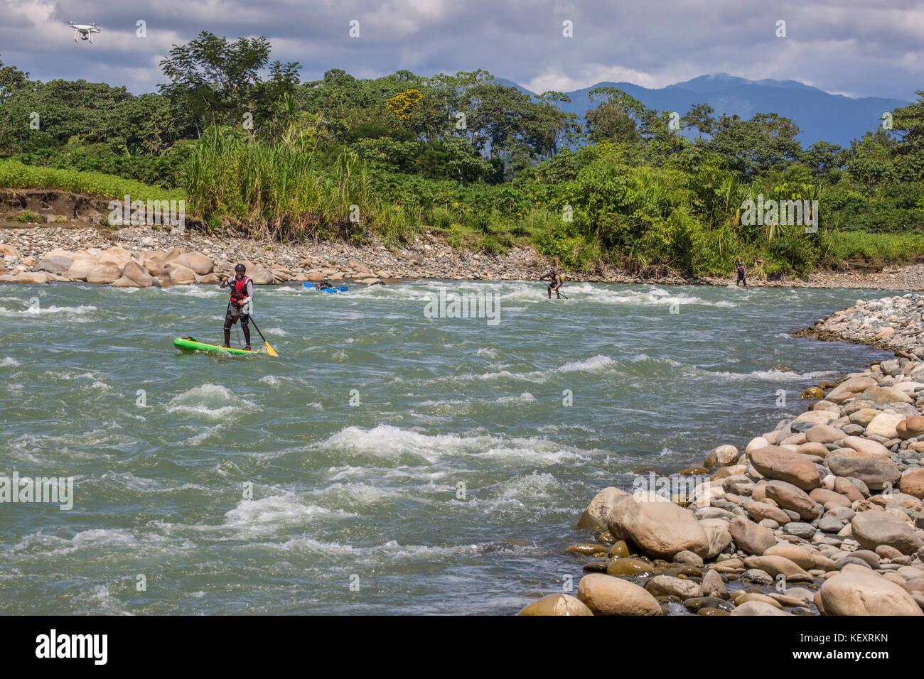 Photograph of men paddleboarding on stand-up paddleboards, Peruvian Amazon, Manu National Park, Peru Stock Photo
